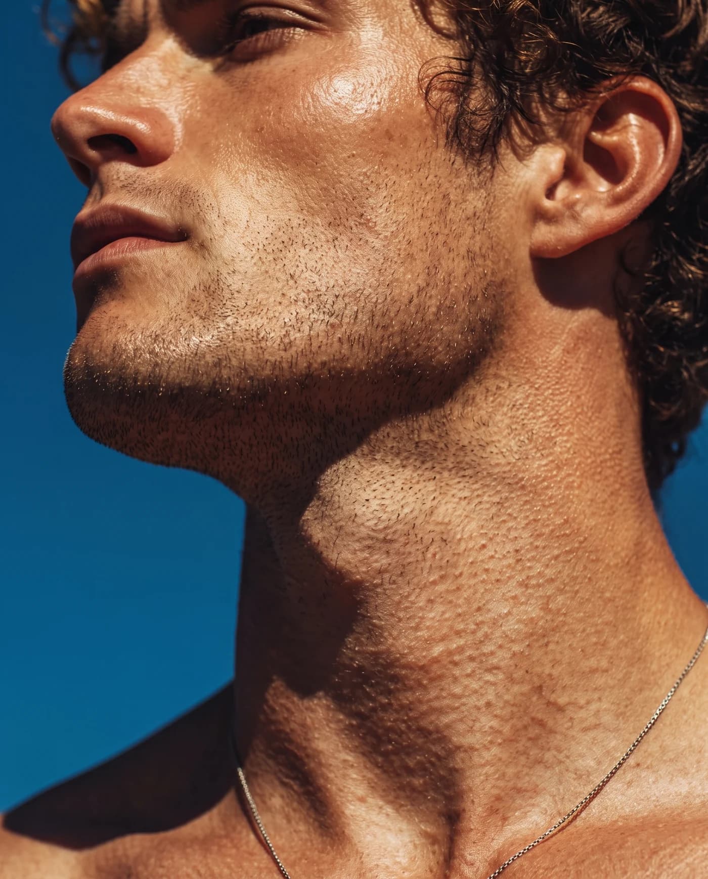 A sunlit close-up of a man’s face with natural skin texture